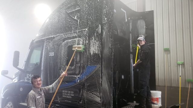 Two RM Trucking employees cleaning a cab